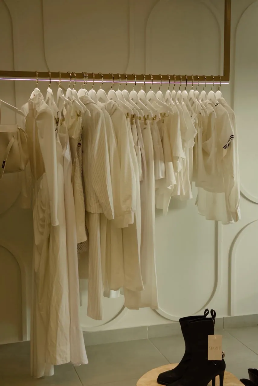 Arara de vestidos cru diante da parede em arcos da boutique em Campo Grande