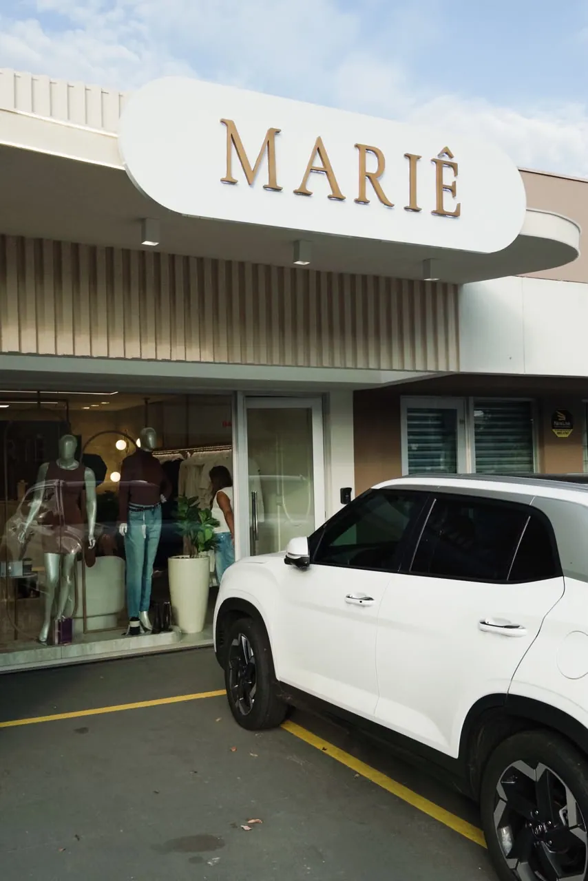 Fachada da Mariê em Campo Grande, com letreiro dourado e vitrine de manequins na rua