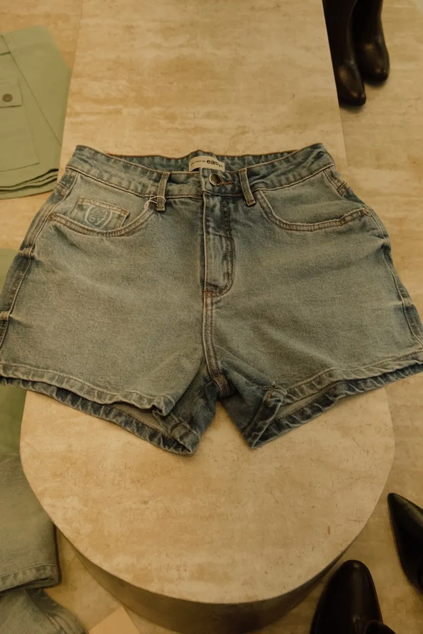 Short jeans claro da linha easy exposto no expositor de travertino da Mariê
